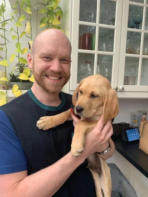 Steve holding a golden retriever puppy